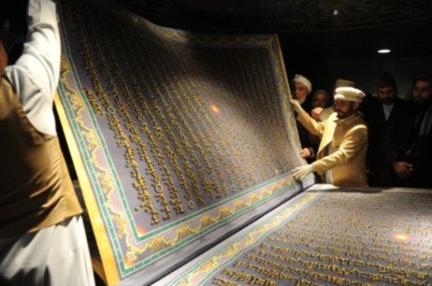 An Afghan artist and his students display an oversized page from the Koran at the Naser Khusro Balkhi Library during an opening ceremony in Kabul on January 12, 2012. The Naser Khusro Balkhi Library was founded by The Aga Khan Foundation in Kabul. AFP PHOTO/ SHAH Marai